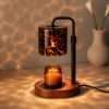 Black pole candle warmer lamp with a leopard print glass cylinder shade over a jar candle on a walnut base