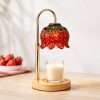 Red glass strawberry shade lit over a jar candle on a round wood base, the GODONLIF strawberry candle warmer lamp