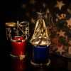 Dark room: the star carousel blurred mid-turn and star shapes thrown on the wall behind the two lit jars
