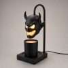 Studio side view of the horned demon head warmer lamp on a pale grey background