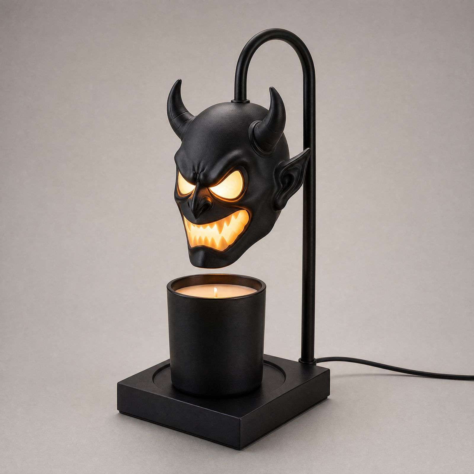Studio side view of the horned demon head warmer lamp on a pale grey background
