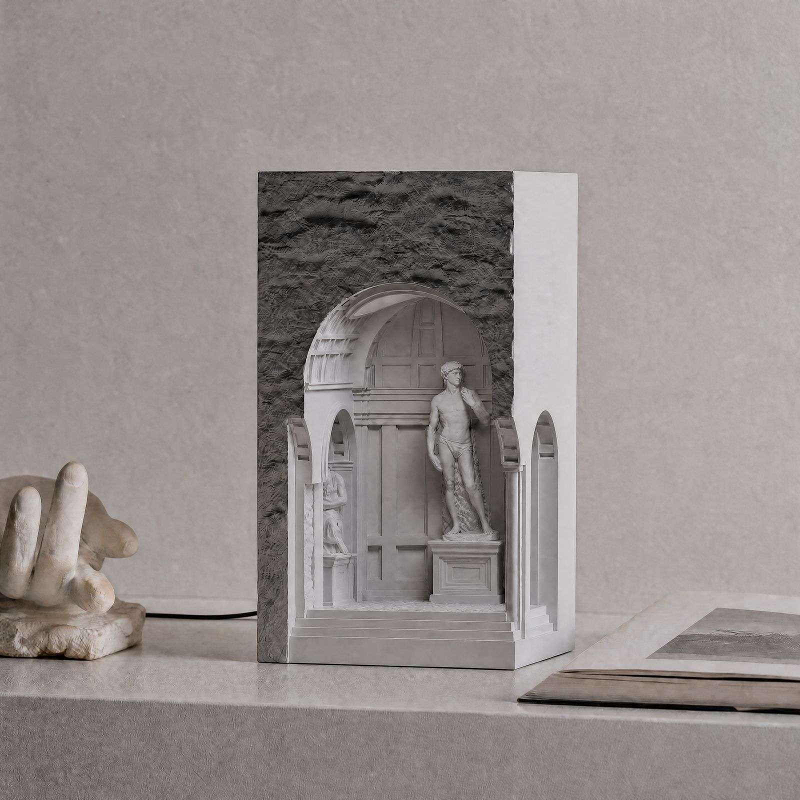 The same niche lamp switched off, showing the grey stone face and the white David figure, one of our plaster lamps