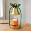 Three-quarter daylight view of the gold bell shade, twisted green stems, tartan bow and round gold base on wood