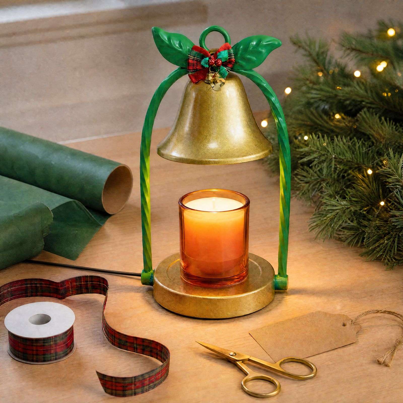 Bell warmer glowing beside green wrapping paper, tartan ribbon, scissors and a blank kraft gift tag