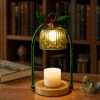Lit green fluted glass bell over a white pillar candle on a round gold base, the GODONLIF green candle warmer