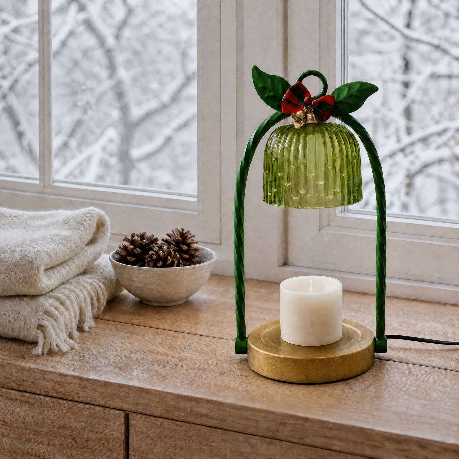 Unlit fluted green glass bell and round gold base on a wood sill, jewel tone decor with a tartan bow