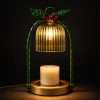Green wax warmer glowing against a dark studio wall, ribbed bell shade over an unlit pillar candle