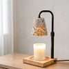 Angled view of the ceramic warmer lamp on a wood dresser, cottagecore home decor with painted daisies