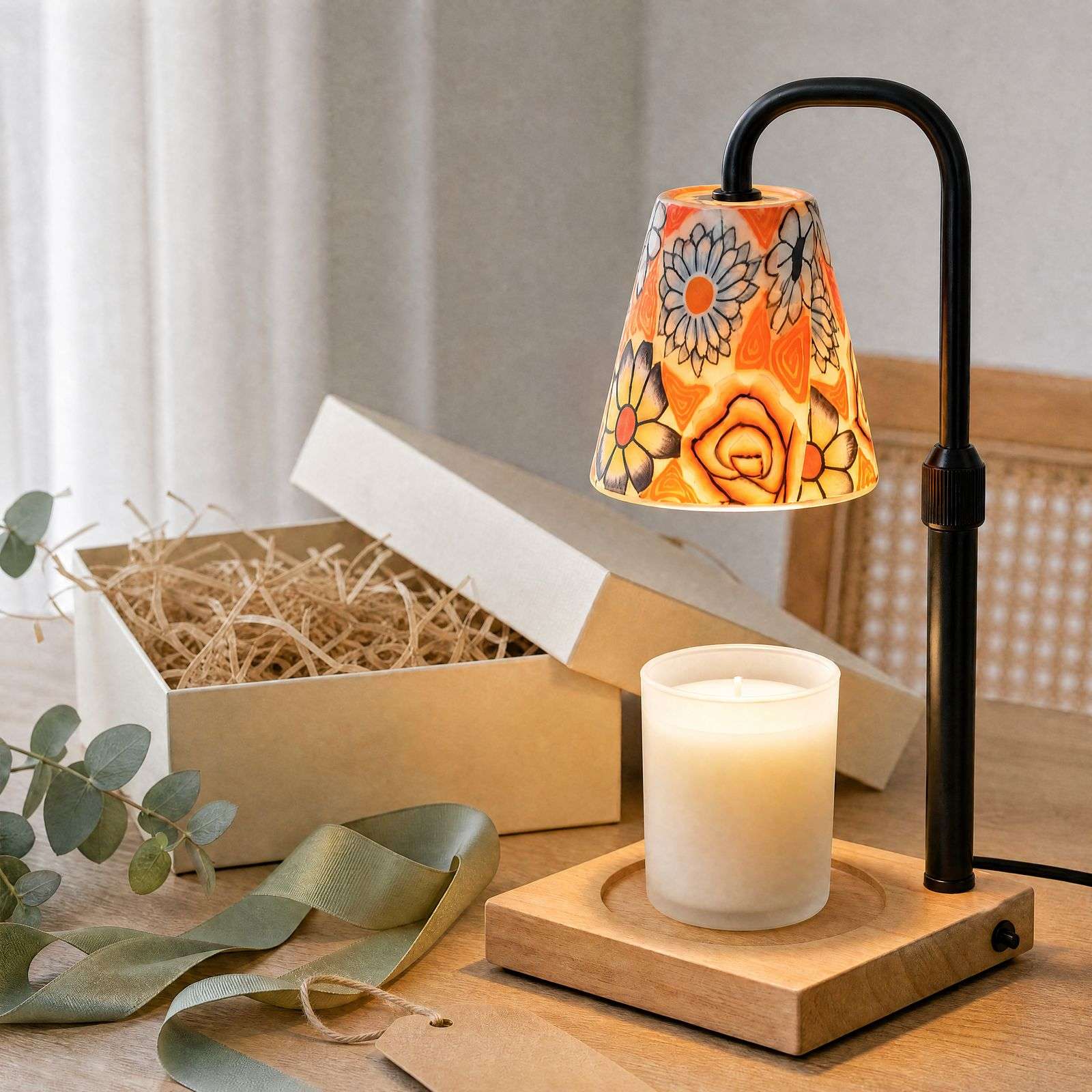 Painted ceramic warmer lit beside a kraft gift box and green ribbon, grandmillennial decor as a present