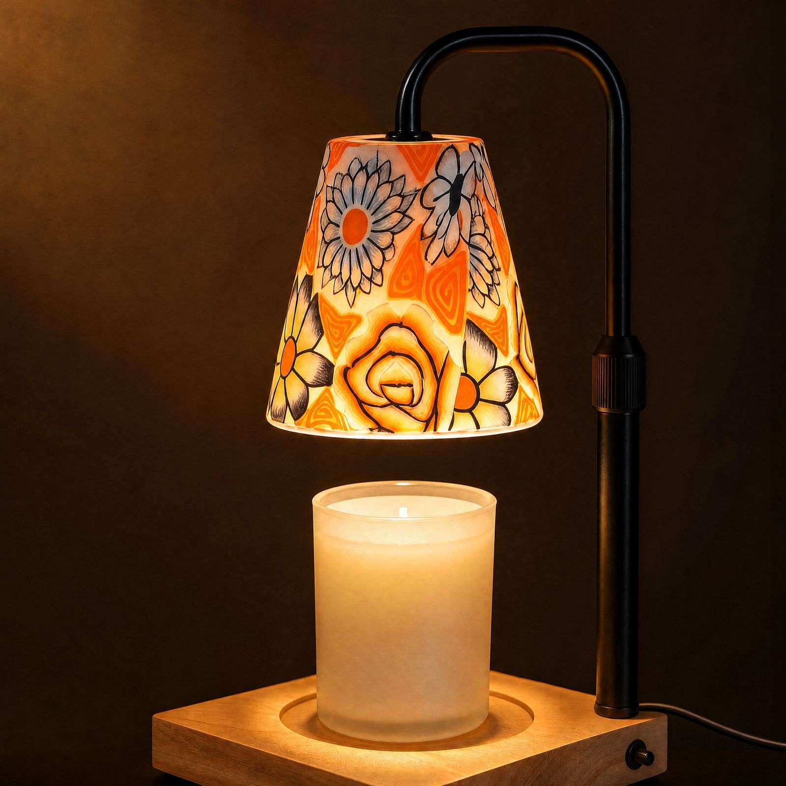 Floral ceramic candle warmer glowing against a dark wall, painted roses and daisies lit from inside