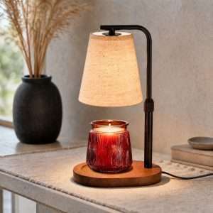 Lit beige fabric shade over a red glass jar candle on an oval wood base, the GODONLIF farmhouse candle warmer lamp