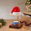 Hat warmer glowing next to an open kraft gift box, tartan ribbon and blank gift tags, ready as Christmas office decor