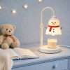 Snowman warmer lit on a blue nightstand beside a teddy bear and star lights, a snowman Christmas lamp at bedtime