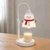 Three-quarter view on a wood table: white hook pole, ribbed collar, round base and the snowman wax warmer shade